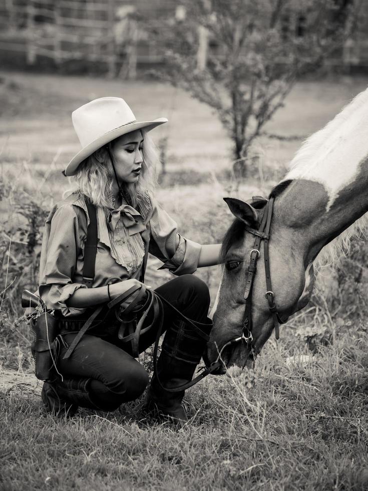 cowgirl touche le cheval avec amour à cause de relations qui sont des amis qui partagent la souffrance et le bonheur ensemble photo