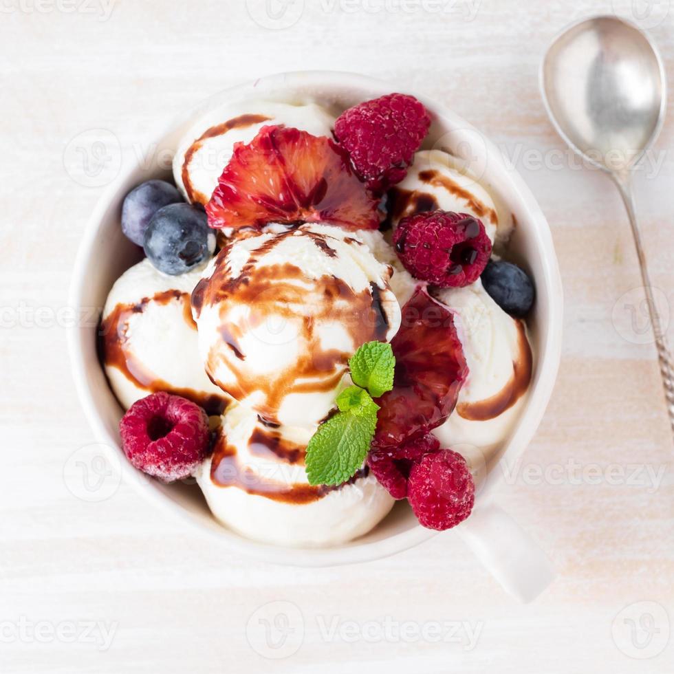 boules de glace à la vanille dans une tasse avec framboise et myrtilles photo