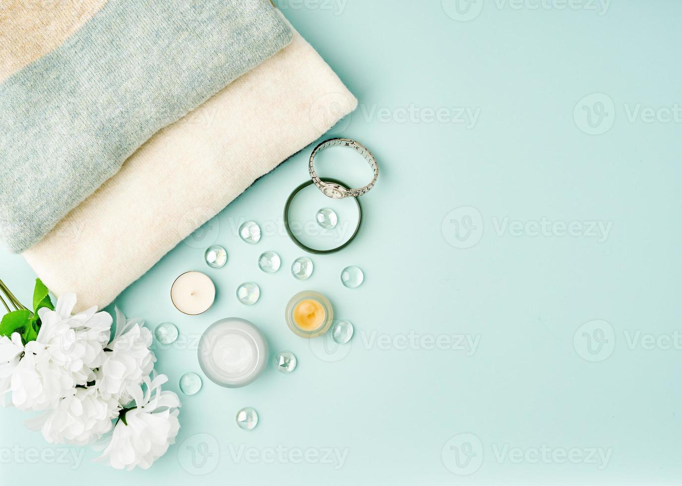 accessoires de femme à plat avec cosmétique, crème pour le visage sur table bleu pastel, espace de copie. photo
