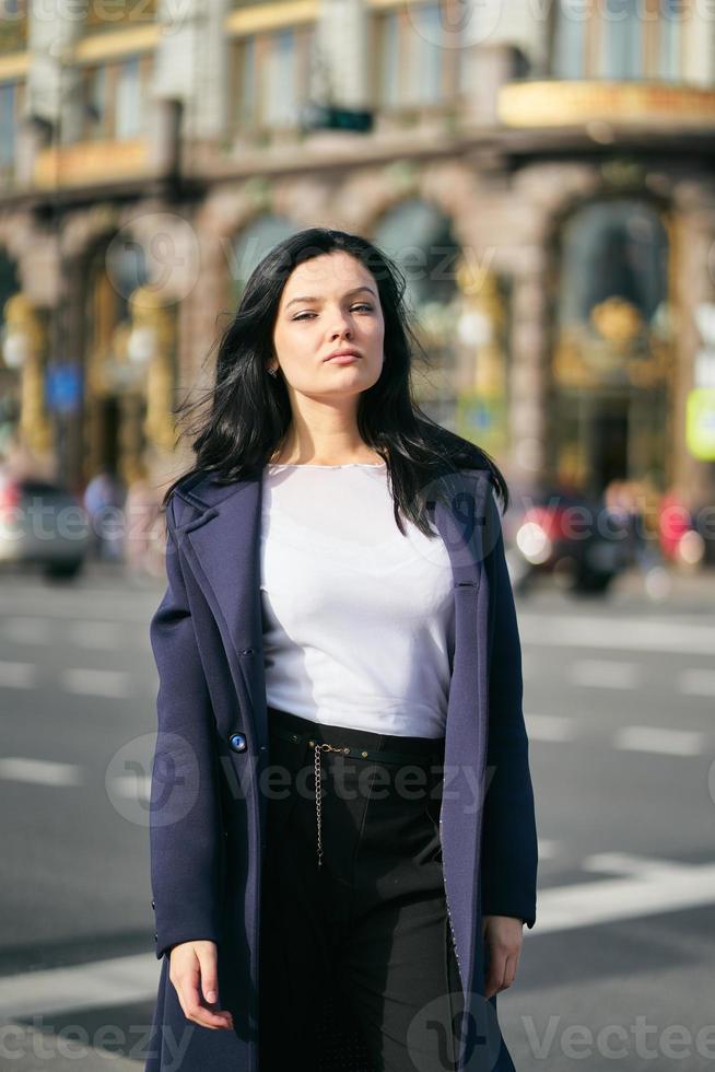 portrait f belle brune intelligente qui marche dans la rue de saint-pétersbourg dans le centre-ville. charmante femme réfléchie aux longs cheveux noirs erre seule, plongée dans ses pensées photo