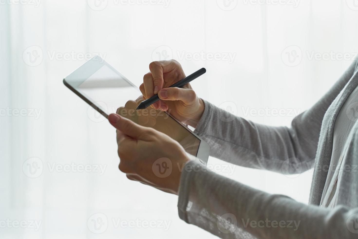 femme tenant une tablette et écrivant dessus, personne avec vue latérale de l'appareil en gros plan photo