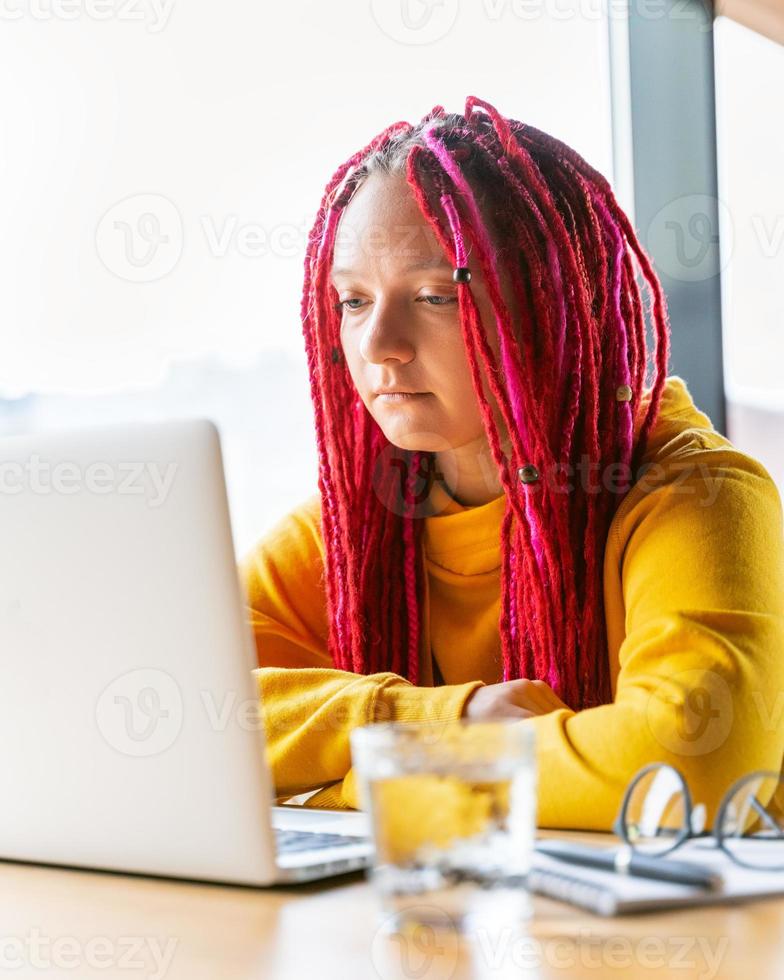 concept de nomade numérique. fille indépendante travaillant à distance sur un ordinateur portable dans un café, coworking. photo