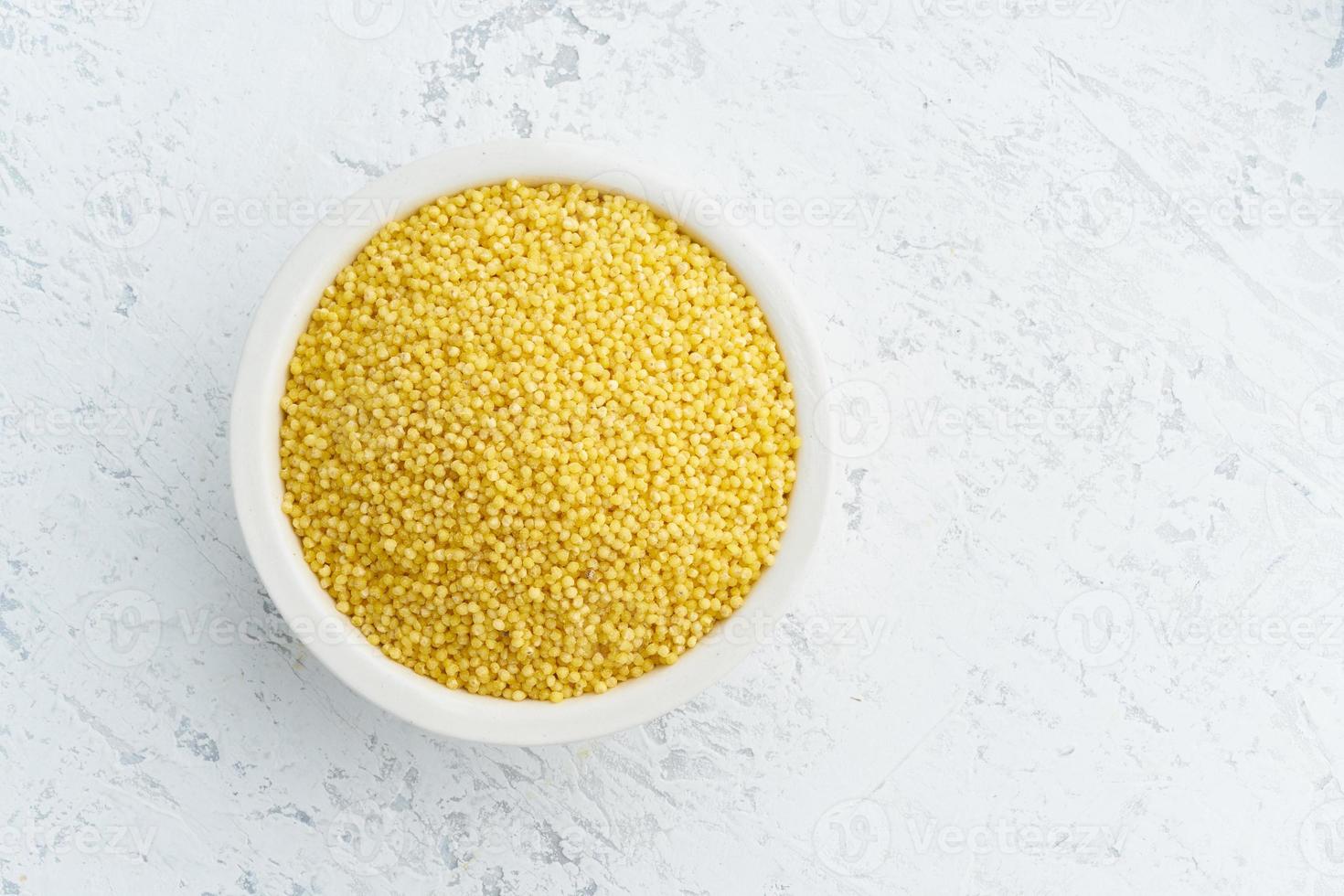 millet, scirpe dans un bol blanc sur fond blanc. sans lectine, céréales séchées dans une tasse, nourriture végétalienne photo