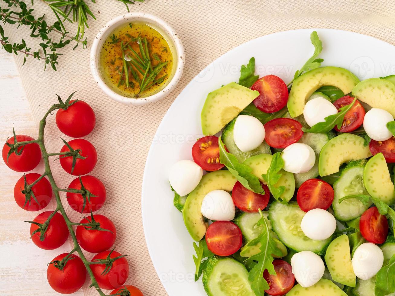 salade fraiche. tomates, concombres, roquette, mozzarella, avocat. huile parfumée au romarin photo