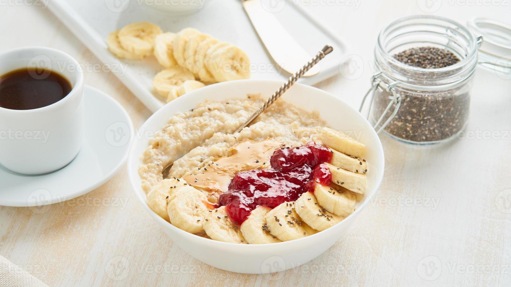 gros plan de bouillie d'avoine, petit déjeuner végétalien sain avec confiture de fraises photo