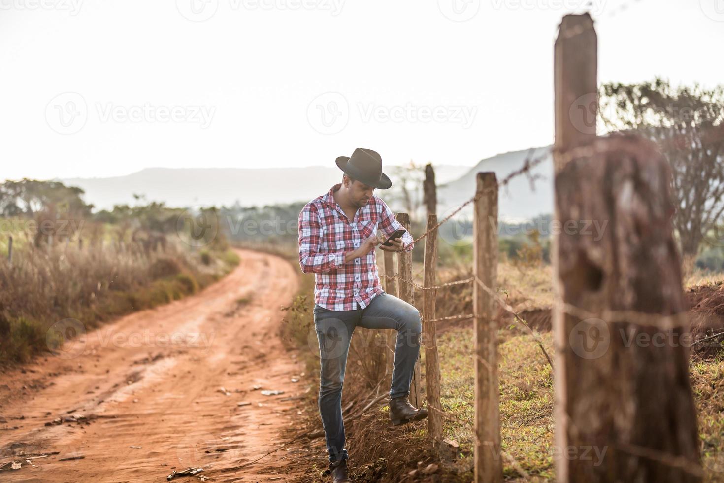 agriculteur ou paysan utilisant un smartphone à la ferme. agriculteur internet 4g. réseaux sociaux, consultations en ligne. photo