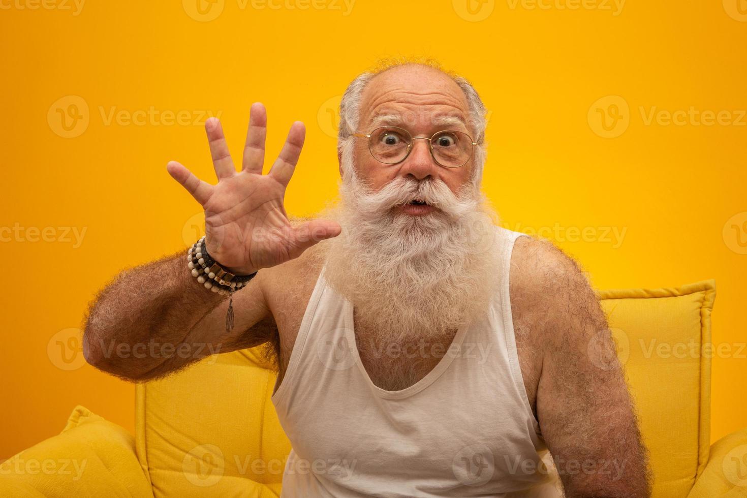 senior souriant avec une longue barbe blanche homme faisant cinq fois un geste de signe avec les doigts de la main sur fond jaune. émotions positives sentiments d'expression faciale, attitude, symbole, compte à rebours. photo