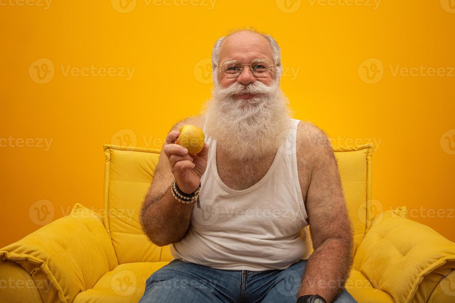 portrait d'un homme barbu sur le point de manger une pomme. senior ayant une pomme. photo