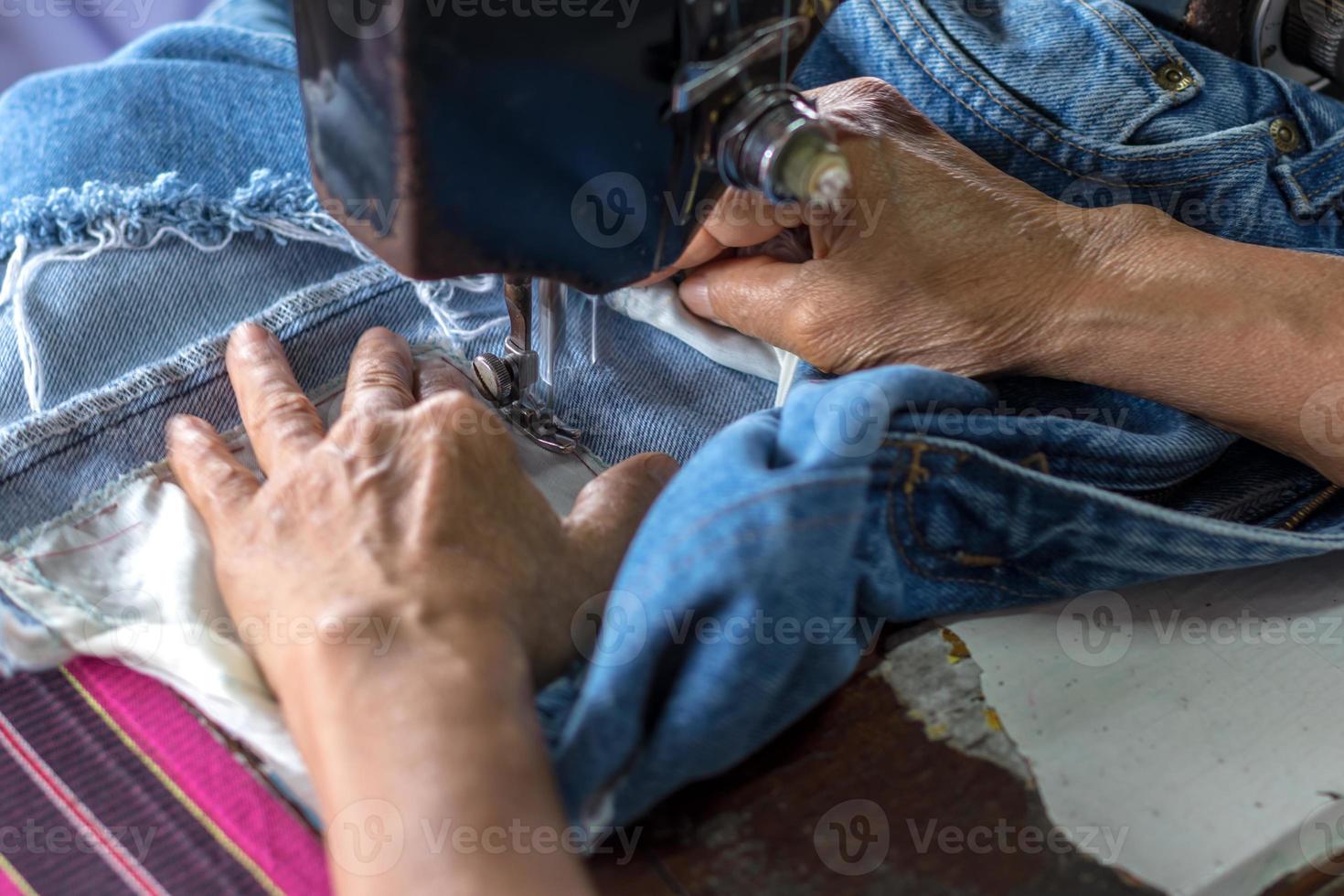 réparer un jean avec une vieille machine à coudre. photo