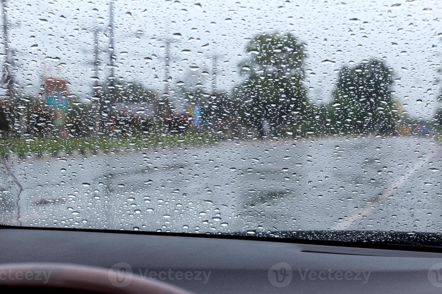 gouttes de pluie sur le pare-brise avec la route. photo
