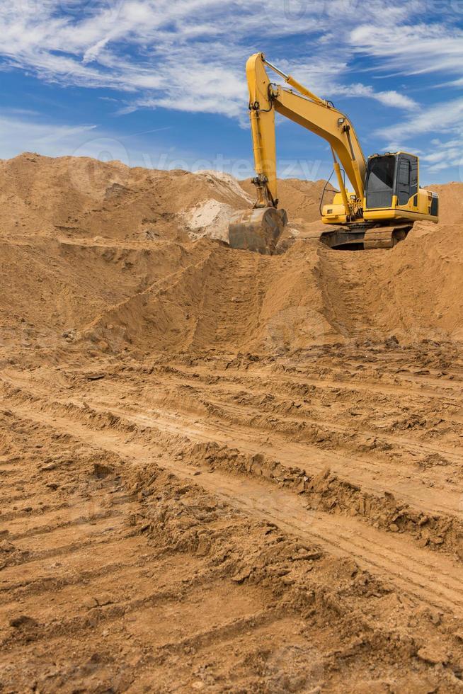 pelleteuse sur le sable contre le ciel. photo