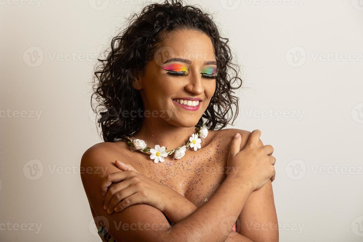 beau jeune modèle souriant avec des fleurs lumineuses sur son cou photo