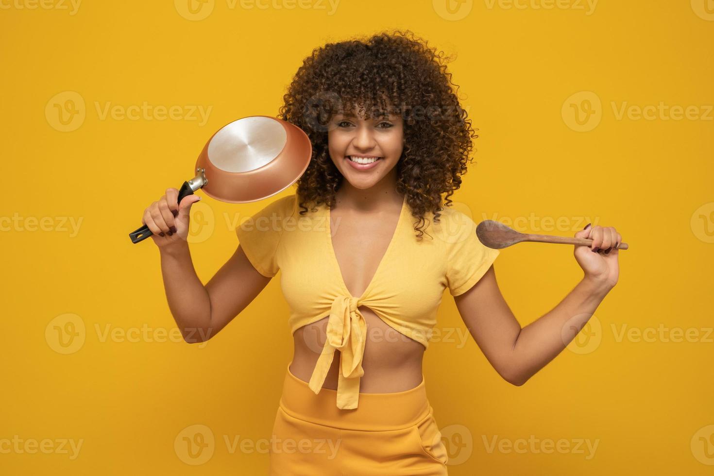 ustensiles de cuisine. cuisine femme dans la cuisine avec poêle à frire et cuillère en bois. femme au foyer qui danse. photo