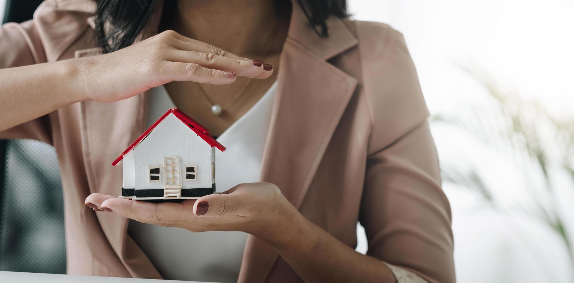 gros plan d'une femme d'affaires détenant une maison modèle. architecture, bâtiment, construction, immobilier et concept immobilier photo