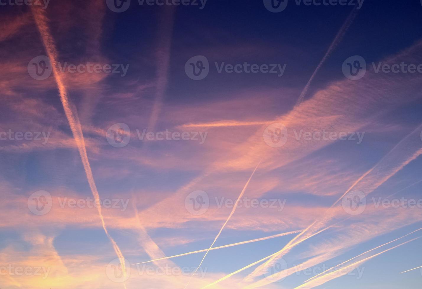 Contraintes de condensation des avions dans le ciel bleu entre quelques nuages photo