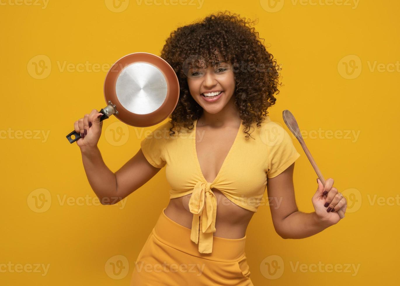 ustensiles de cuisine. cuisine femme dans la cuisine avec poêle à frire et cuillère en bois. femme au foyer qui danse. photo