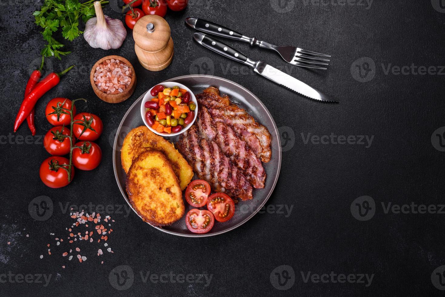 tranches de délicieux bacon grillé avec croûtons frits dans un œuf avec épices, sel, légumes et herbes photo