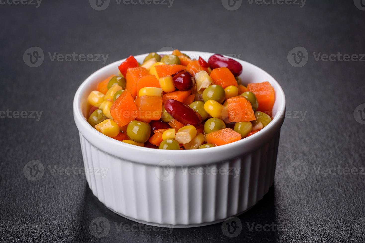 un mélange de légumes hachés paprika, maïs, pois en plaque blanche photo