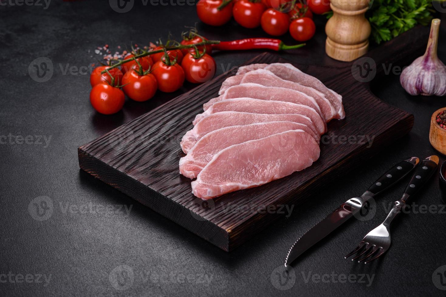 viande de porc fraîche crue tranchée sur une planche à découper en bois photo