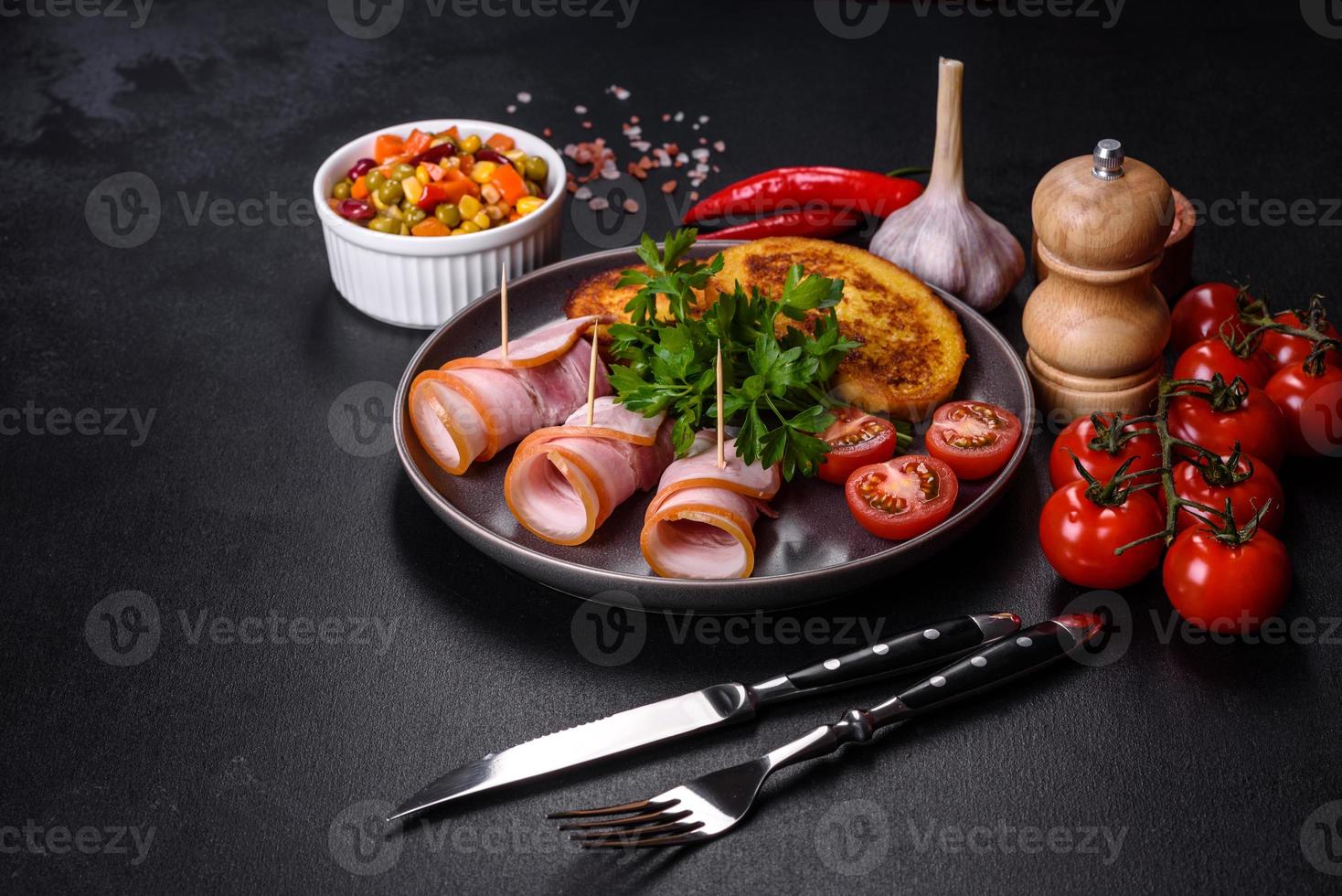 tranches de délicieux bacon cru ou salé avec épices, sel, légumes et herbes sur une planche à découper en bois photo