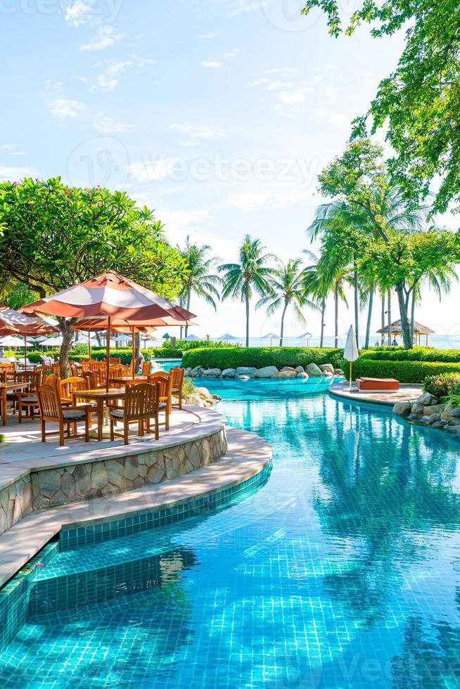 parasol avec chaise et table autour de la piscine photo