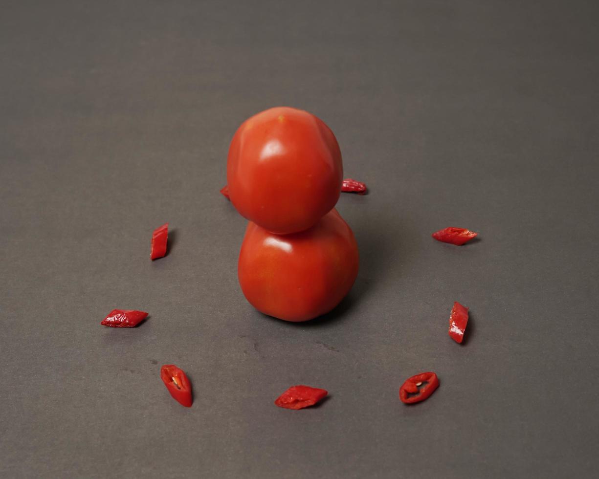 la combinaison de tomates fraîches, de piments rouges et d'œufs forme un visage souriant. ingrédients de cuisine prêts à être servis. flou de mise au point, inspiration d'arrière-plan. combinaison de couleurs noir et rouge. photo