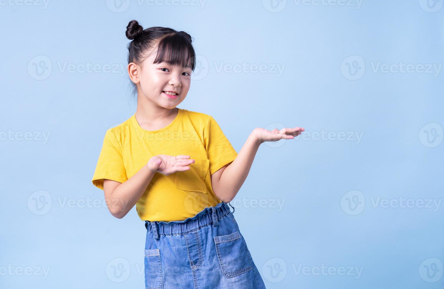 image d'enfant asiatique posant sur fond bleu photo