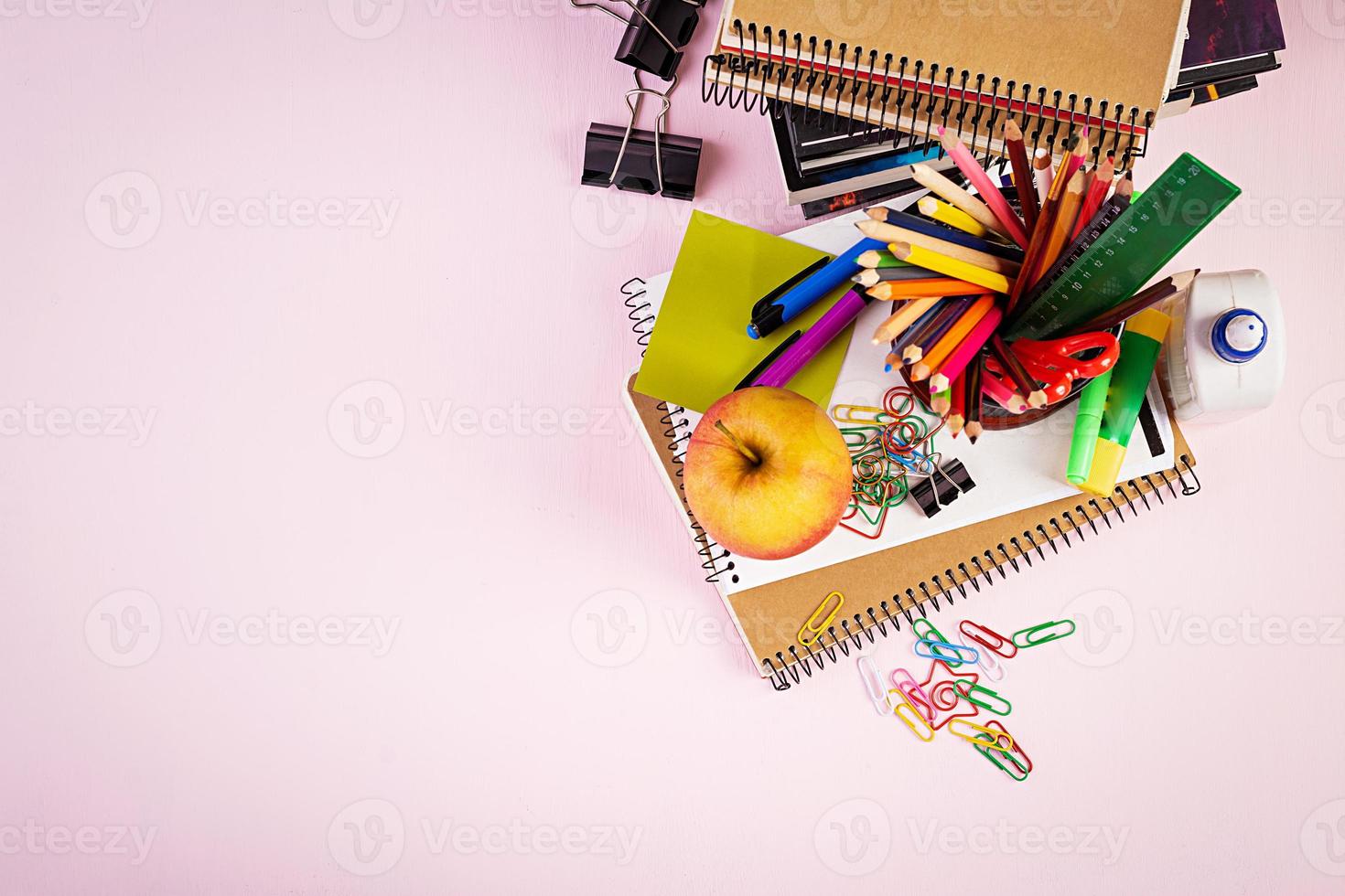 ensemble de fournitures scolaires colorées, livres et cahiers. accessoires de papeterie. vue de dessus. photo