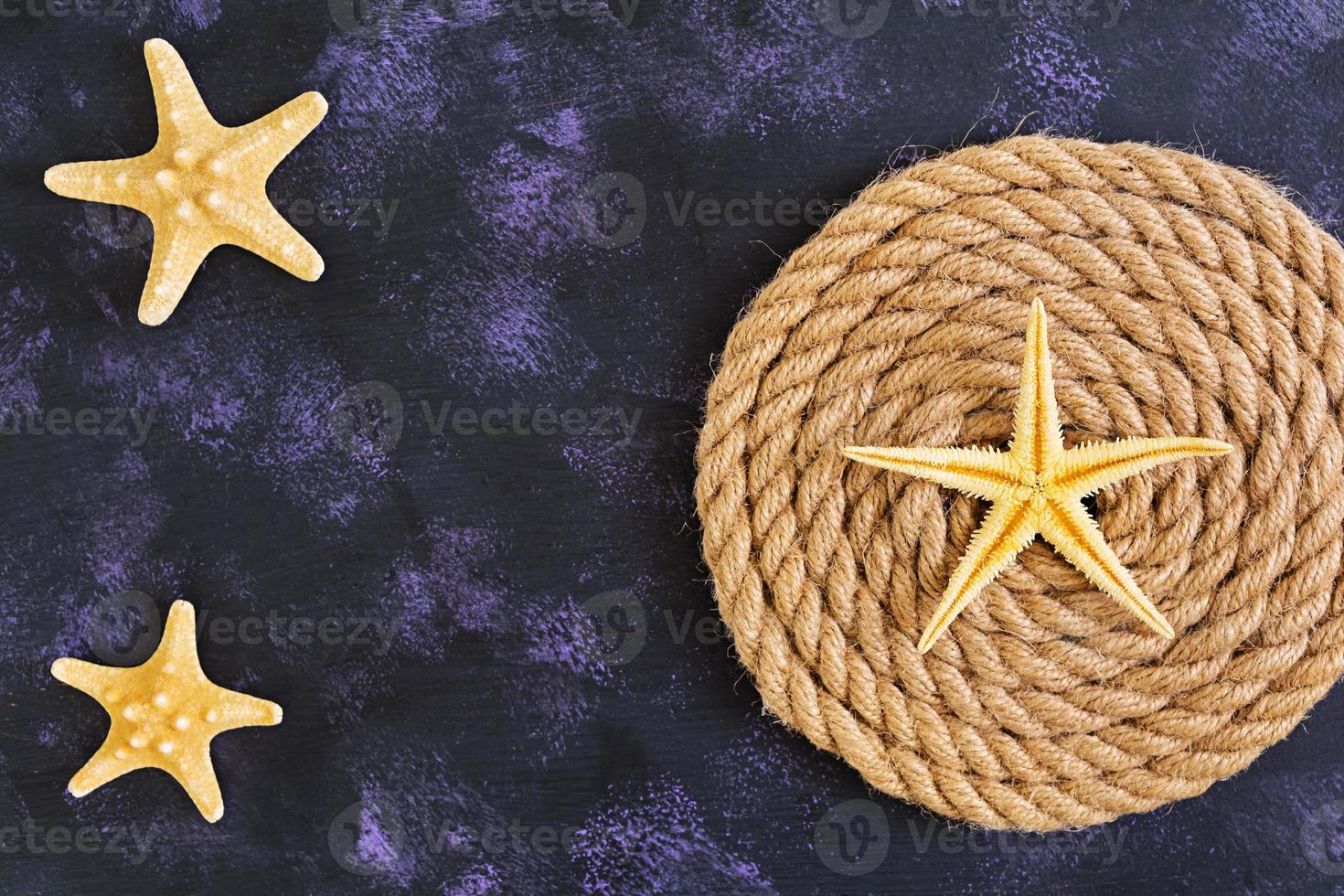 corde et étoile de mer sur fond sombre. vue de dessus photo