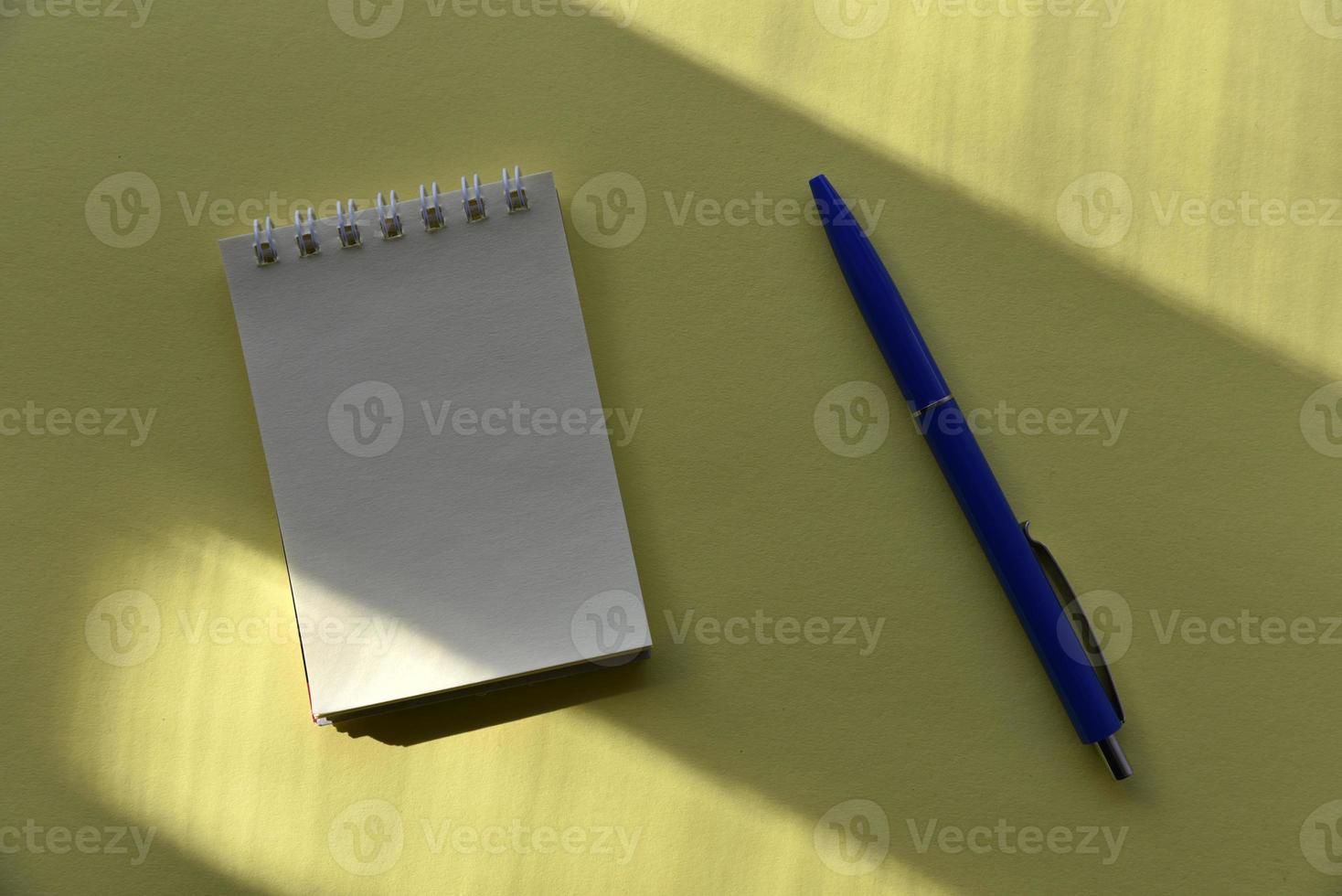 stylo plume bleu et bloc-notes sur fond jaune photo