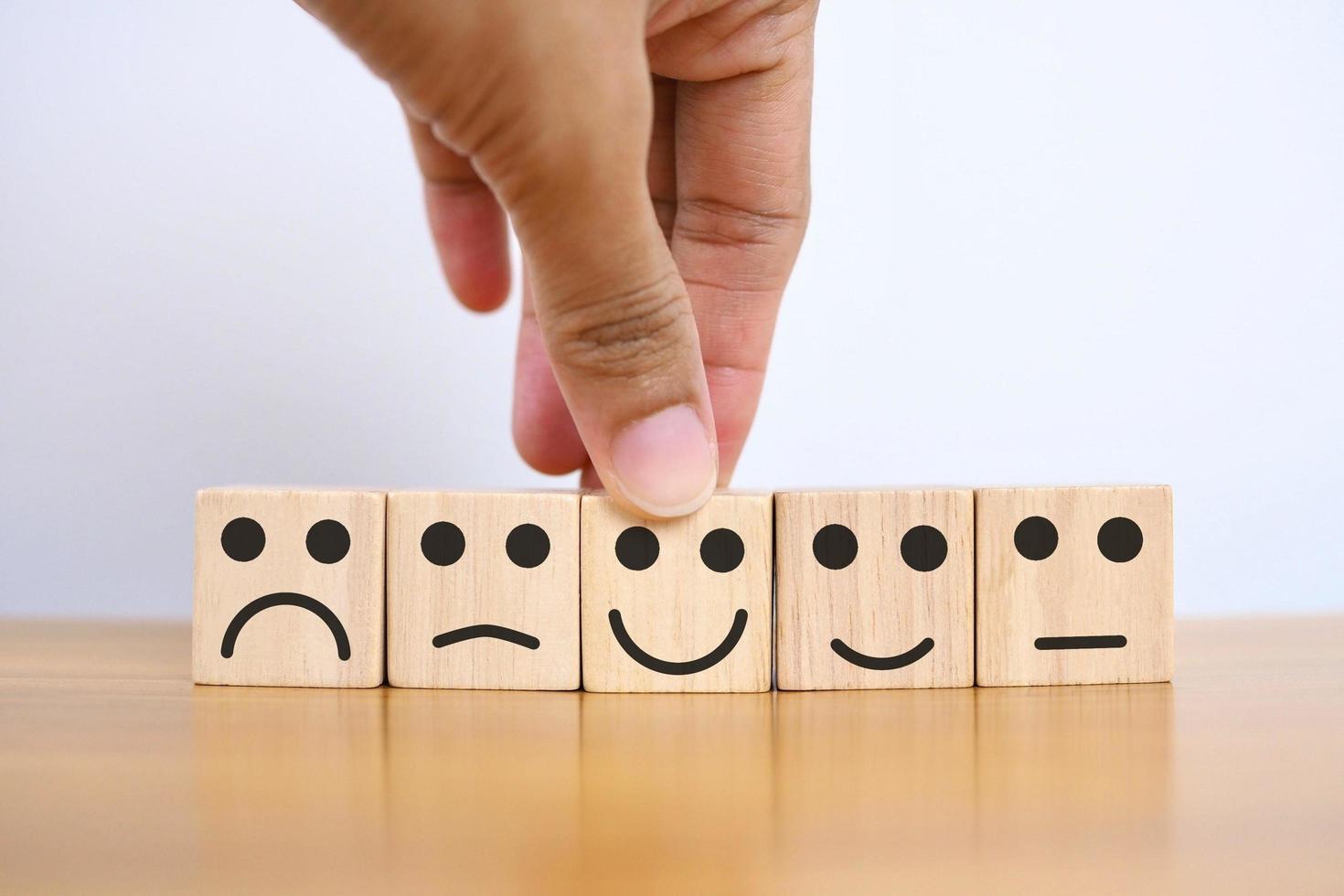 concept d'évaluation de la satisfaction icône de smiley heureux sur un cube en bois sur la table. photo