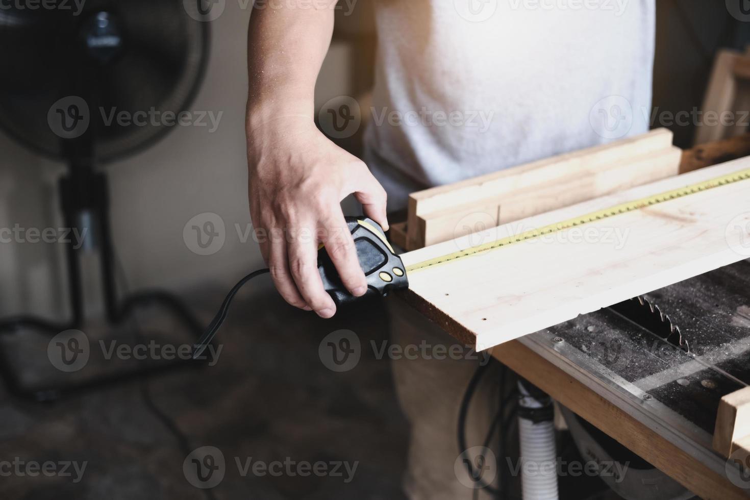 les artisans du concept de bricolage utilisent un ruban à mesurer pour assembler des pièces en bois afin de fabriquer des tables en bois pour les clients. photo