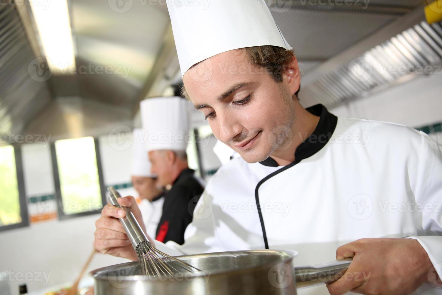 jeune cuisinier travaillant dans la cuisine photo