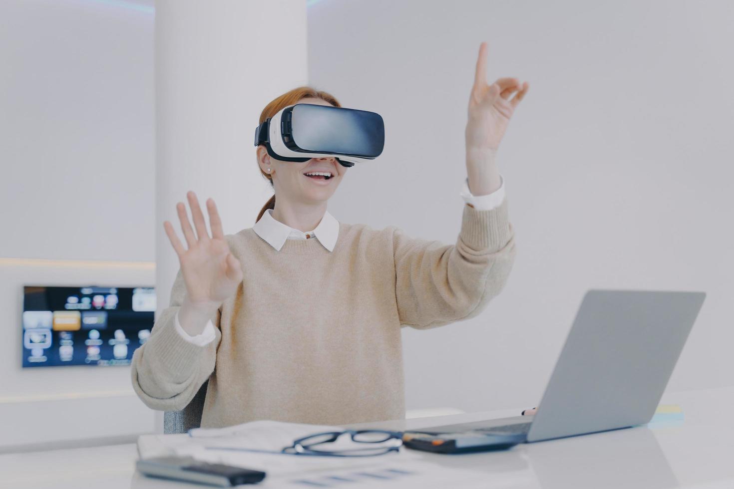 heureuse fille européenne dans des lunettes de réalité virtuelle. pigiste travaillant sur un projet d'effets visuels. photo