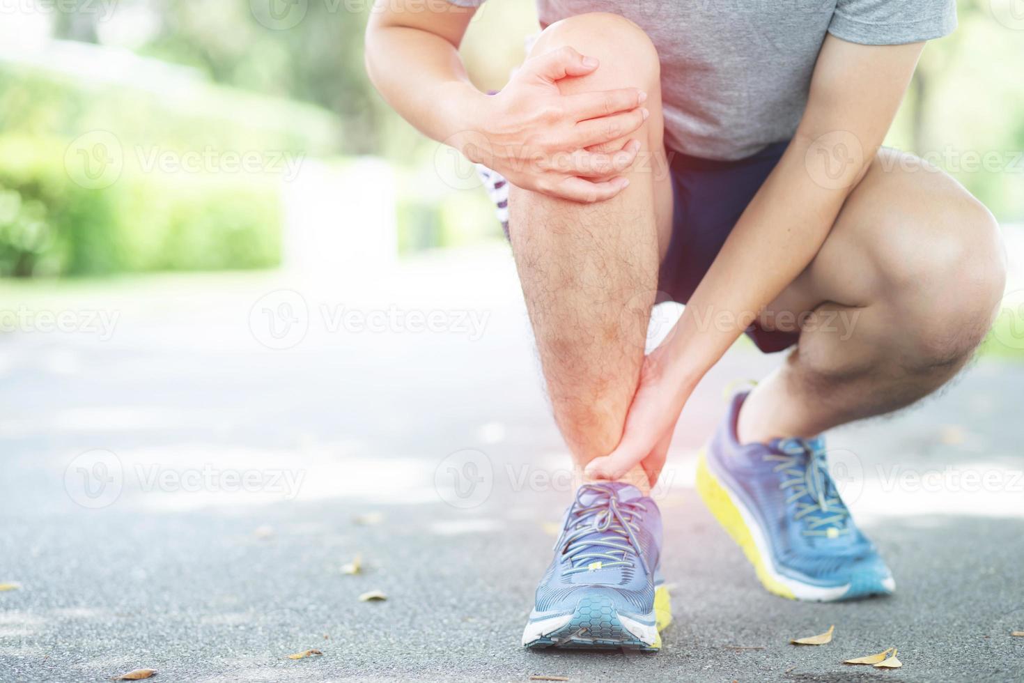 le jogger a pris la main à la cheville avec une douleur de mouvement photo