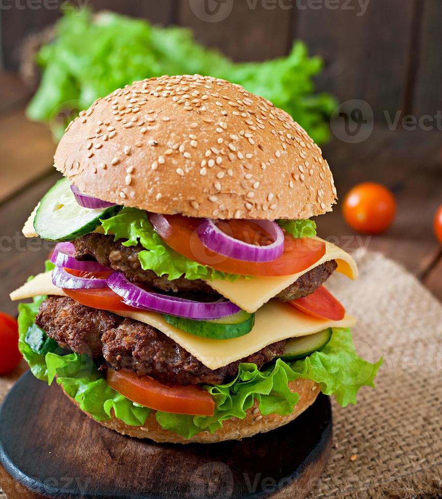 gros hamburger juteux avec des légumes et du boeuf sur un fond en bois de style rustique photo