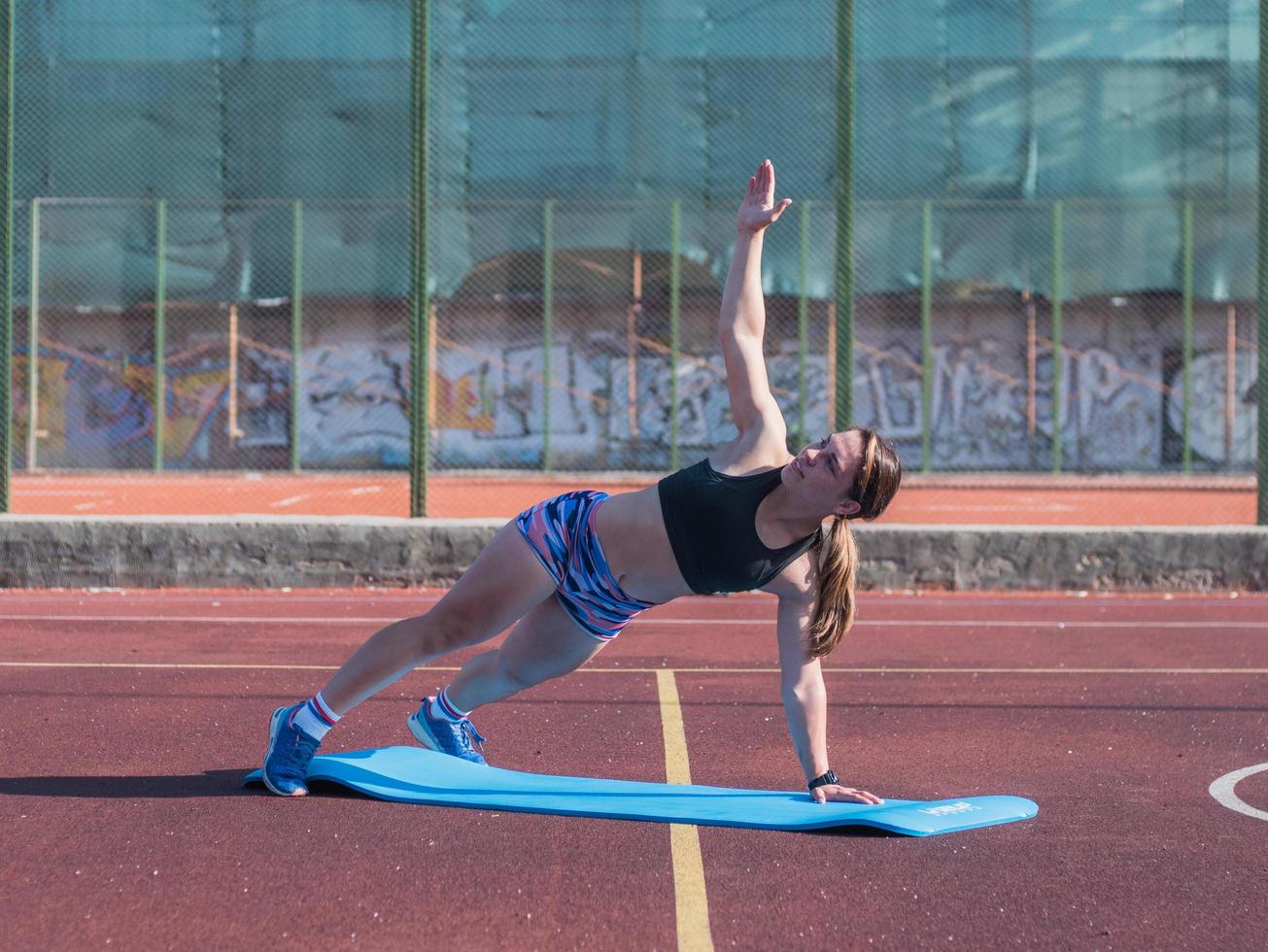 jeune femme forte s'entraînant à l'extérieur en été, une athlète professionnelle féminine fait des exercices dans le parc photo