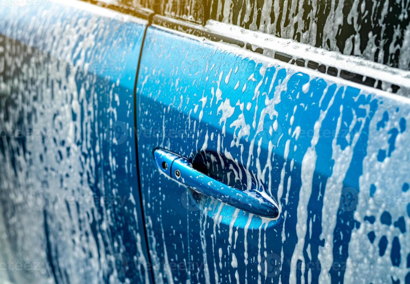 lavage de voiture bleu avec de la mousse de savon blanche. entreprise d'entretien automobile. nettoyage de voiture et brillant avant le service de cirage. service de nettoyage de véhicules avec antiseptique et désinfection du coronavirus covid-19. Lave-Auto. photo