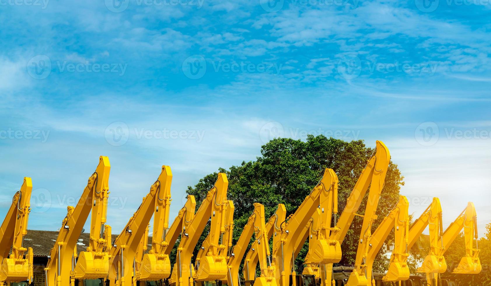 rétrocaveuse jaune avec bras de piston hydraulique. énorme bulldozer en métal. excavatrice. machines hydrauliques. industrie des machines lourdes. génie mécanique. stock de pelleteuse au parking de l'usine. photo