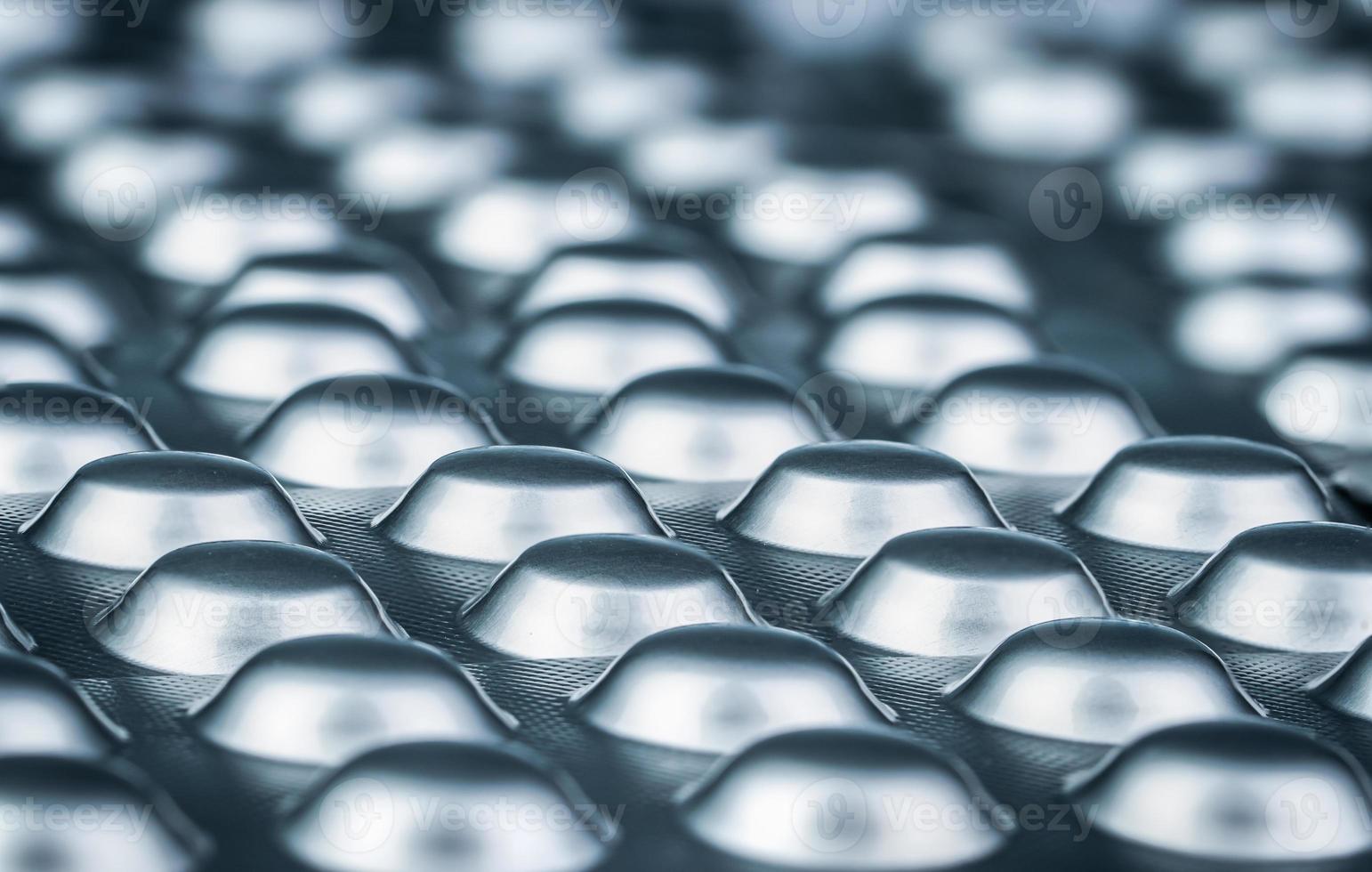 comprimés comprimés sous blister de papier d'aluminium argenté. industrie pharmaceutique. de nombreux emballages sous blister de pilules avec lumière. médicaments pour le traitement de la maladie. concept de pharmacologie et de pharmacie. photo