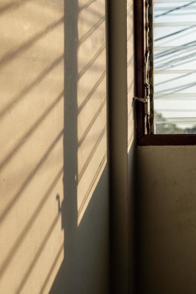 ombre du soleil sur le mur avec de vieilles fenêtres à persiennes. photo