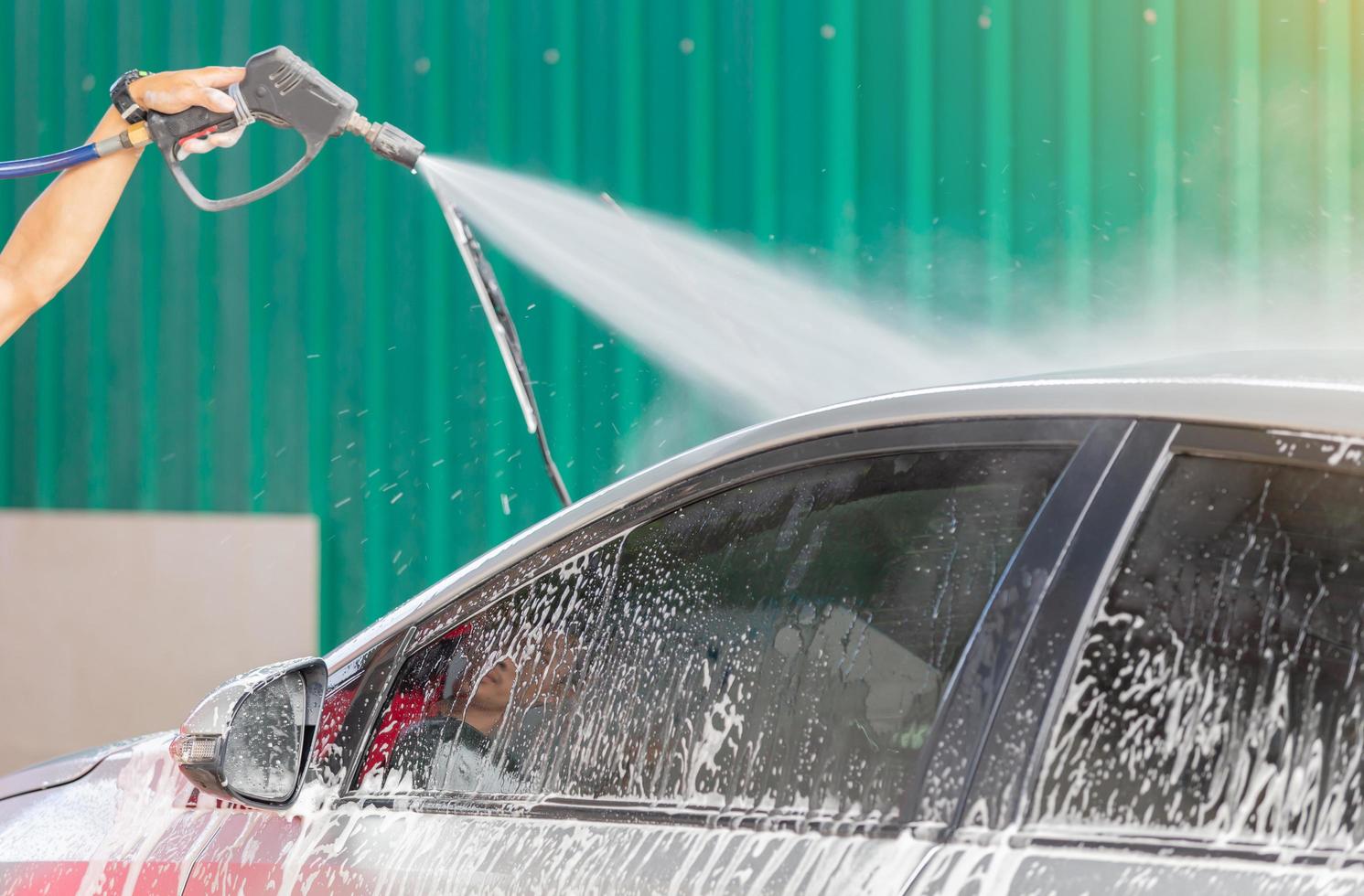 lavage de voiture avec savon et lavage à haute pression, concept d'entretien. photo