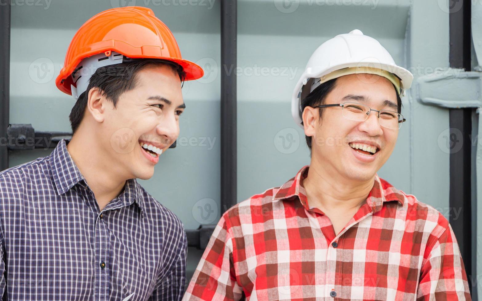 ingénieur joyeux et équipe de contremaître sur le chantier de construction, ouvrier d'usine de bonheur dans un casque au conteneur de fret photo