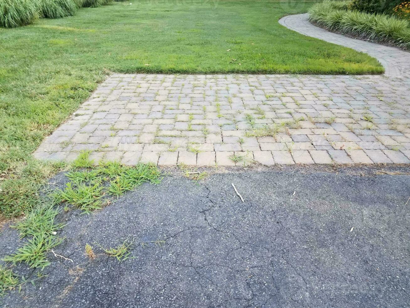 chemin d'asphalte ou de chaussée et de pierre avec des herbes et des fissures photo