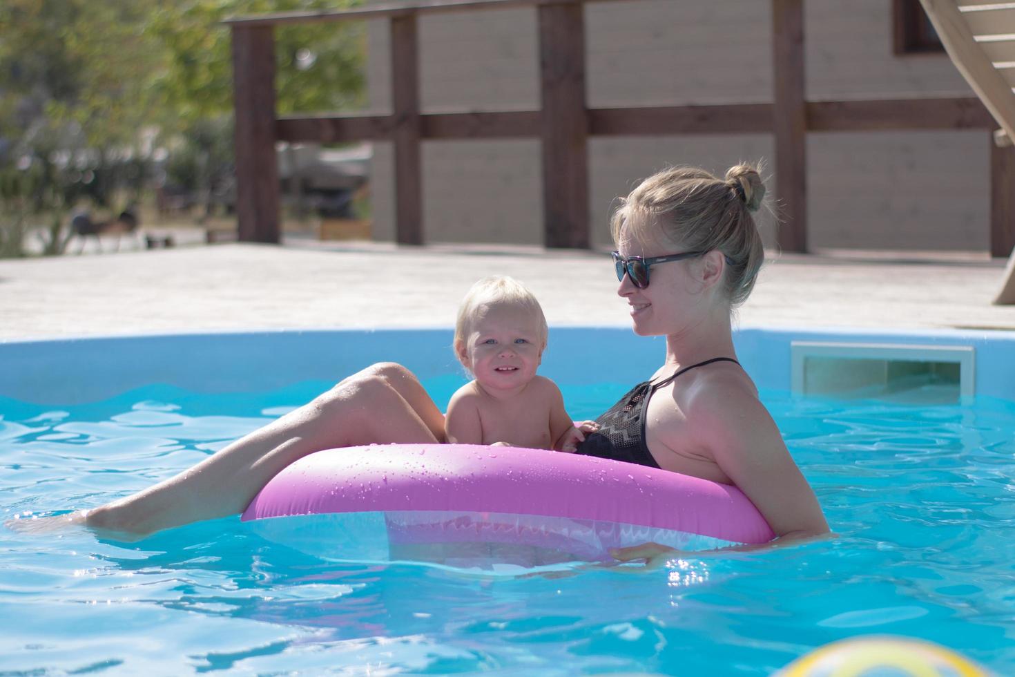 famille heureuse s'amusant dans la piscine bleue photo