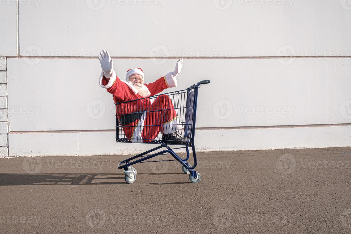 chariot de supermarché avec le père noël à l'intérieur. shopping pour le concept de noël. photo