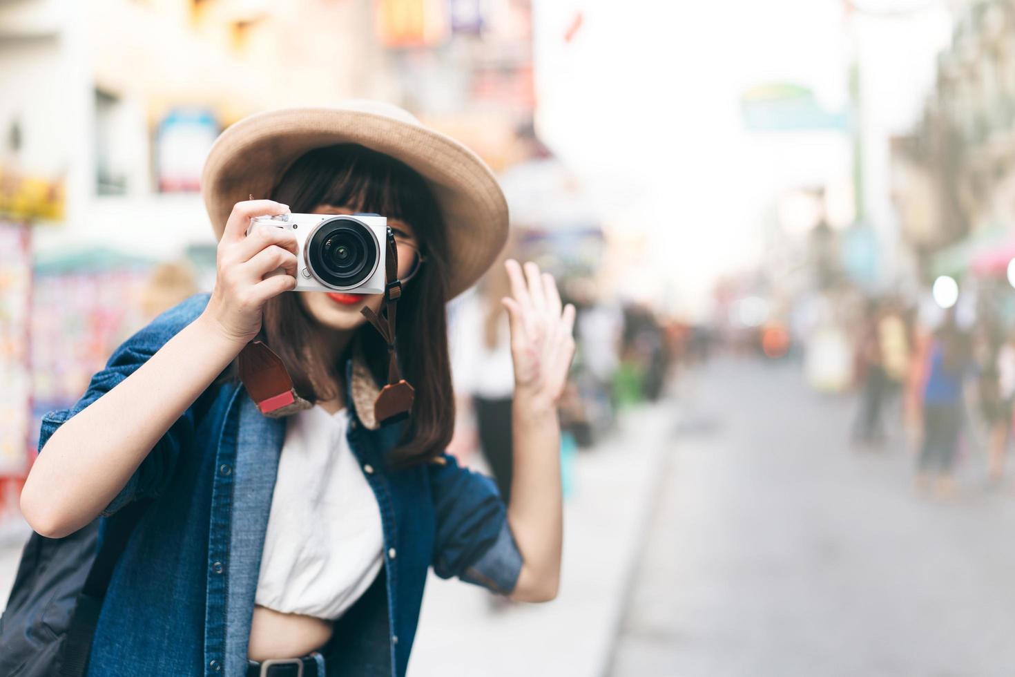 une jeune voyageuse asiatique prend une photo par appareil photo sur la route de la rue khaosan.