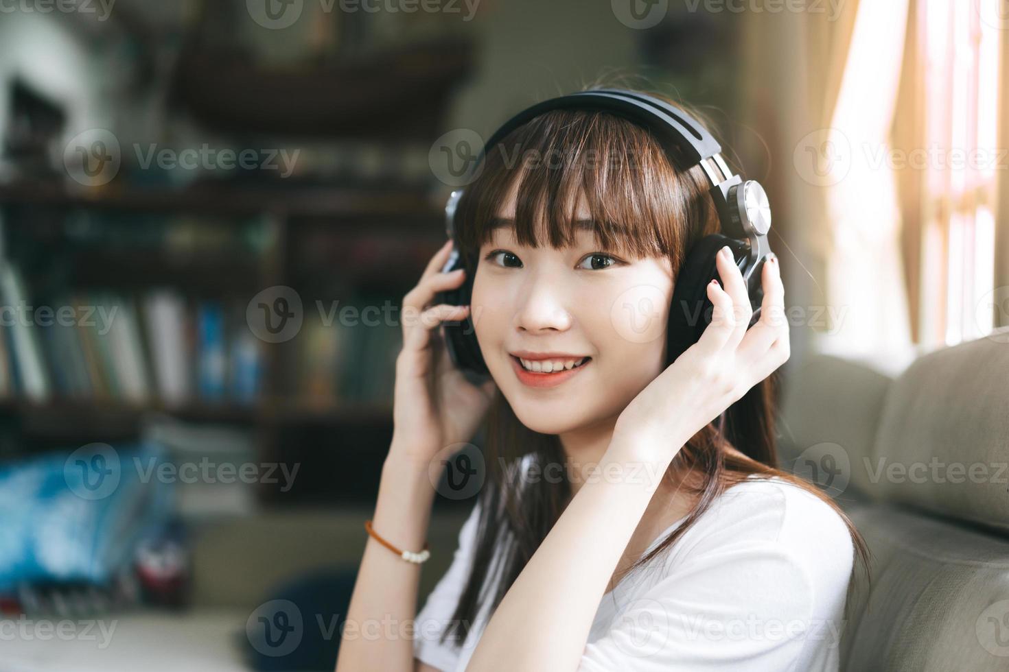 une adolescente asiatique écoute de la musique avec un casque reste à la maison. photo