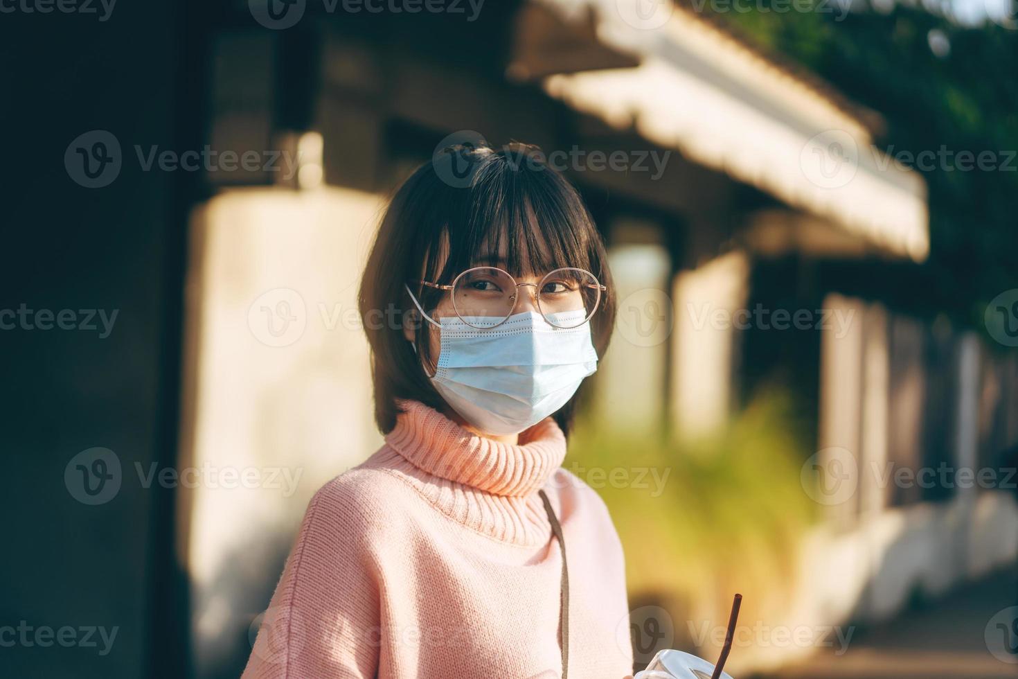 jeune adulte asiatique lunettes femme porter un masque facial pour protéger le virus corona ou covid19. photo