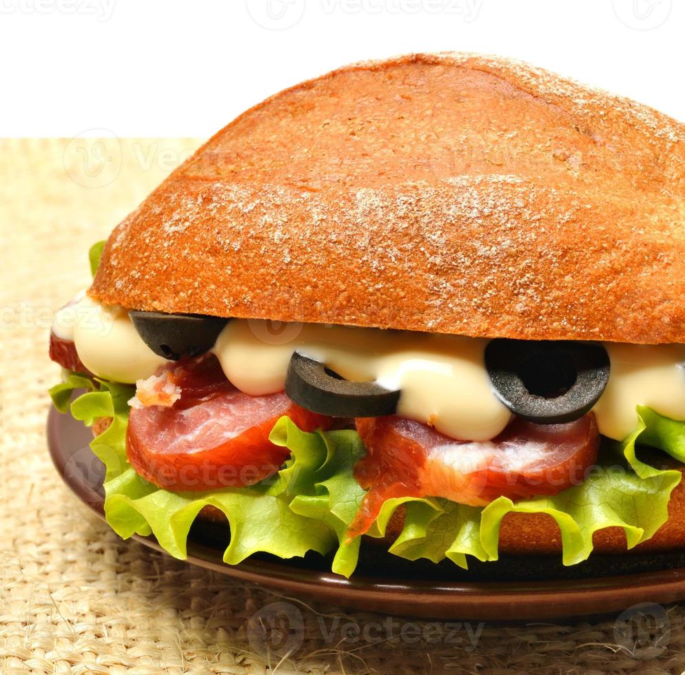 savoureux sandwich frais avec laitue verte, jambon, olives sur sac photo
